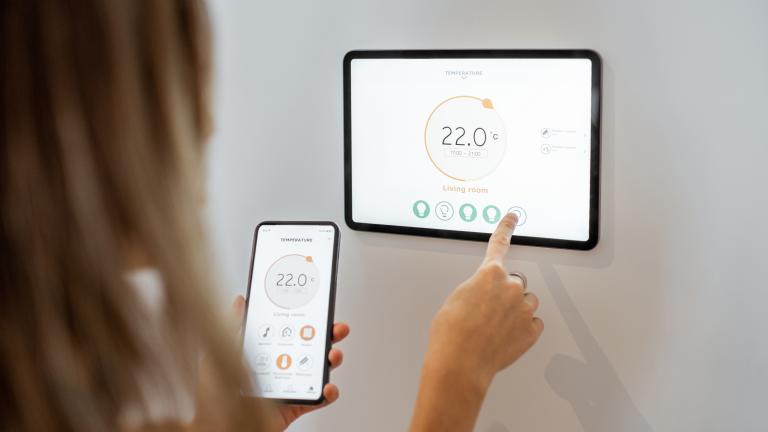 woman-controlling-heating-with-a-smart-devices